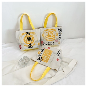 Detailed macro view of three canvas tote bags with traditional Chinese calligraphy and yellow handles