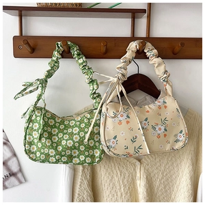 Close-up of floral shoulder bags featuring scrunchie handles and side bow details