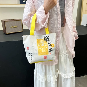 Spacious canvas tote bag with yellow handles and traditional folk art calligraphy design