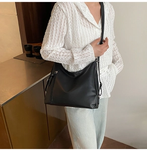 Detail of a black matte hobo bag with long zipper and slim strap for daily commuting