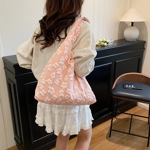 Chic pink shoulder bag with 3D floral textures and minimalist crescent tote shape