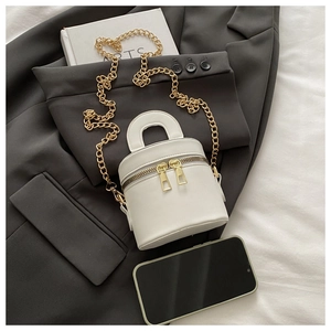 Minimalist white cylinder crossbody bag with gold chain and double zipper details