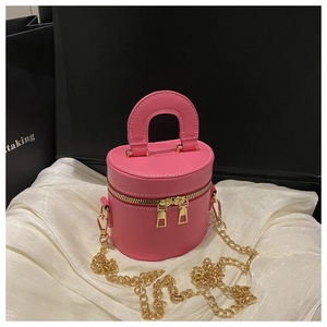 Detail of rose red cylinder crossbody bag with golden chain and double zippers