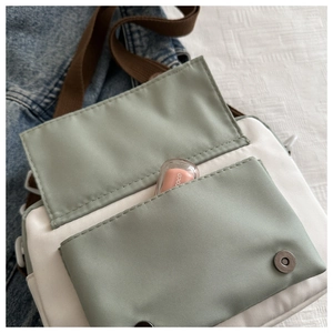 Close-up of contrast crossbody bag with magnetic flap showing small lipstick storage