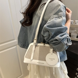 Chic white leather and beige mesh shoulder bag with adjustable strap worn by model