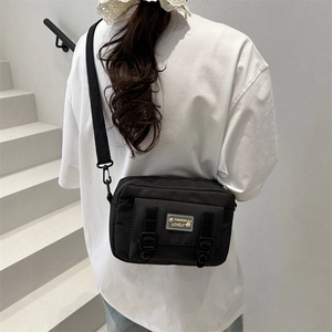 Chic black nylon crossbody bag with minimalist flap design and adjustable strap for women