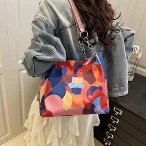 Fashionable large tote bag with colorful abstract geometric prints and pink leather straps