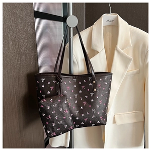 Dettaglio della borsa tote marrone a fiori con pochette coordinata e fibbie in metallo