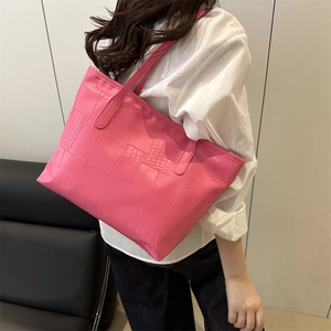 Pink large capacity tote bag with crocodile texture pattern on a female model shoulder