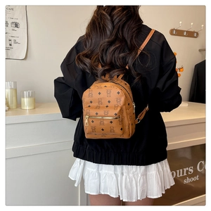 Gros plan du mini sac à dos marron avec motifs d'ours noirs et poche avant zippée en métal