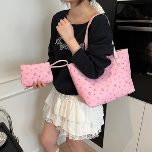 Set di borsa tote rosa con fiori e pochette coordinata indossata da modella in cucina