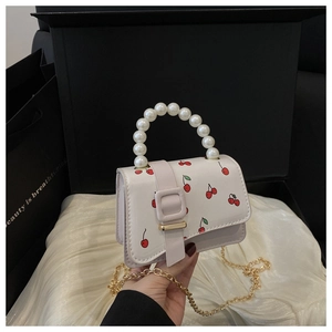 Detail of pearl handle and cherry print on white leather mini bag with gold chain