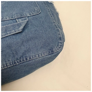 Close-up of vintage washed denim tote bag showing distressed edges and white topstitching