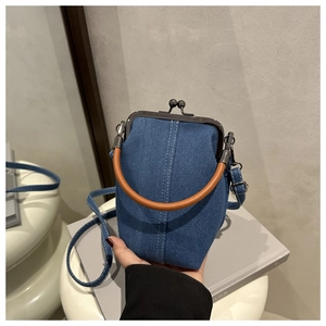 Detailansicht der Retro-Jeans-Handtasche mit Kussverschluss und braunem Ledergriff