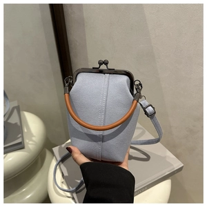 Detail der hellblauen Jeans-Handtasche mit Metallverschluss und braunem Griff im Retro-Stil