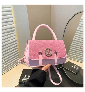 Pink denim crossbody bag with gold M-logo clasp and adjustable shoulder strap detail