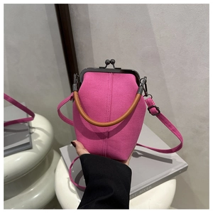 Detail der rosaroten Canvas-Handtasche mit dunklem Metallverschluss und Ledergriff