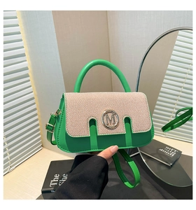 Detail of trendy color-block crossbody bag with knit texture and golden M-logo clasp