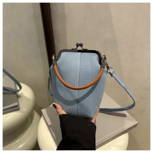 Detail der blauen Denim-Arztasche mit braunem Ledergriff und Metallrahmen-Verschluss
