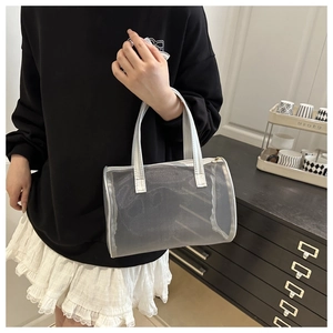 Bolso tipo saco de malla plateada con asas metálicas en un entorno casual