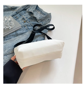 Gros plan du sac fourre-tout blanc avec sangle noire tissée et coutures de base renforcées