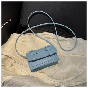 Top-down view of a light blue mini square crossbody bag on a white textured fabric