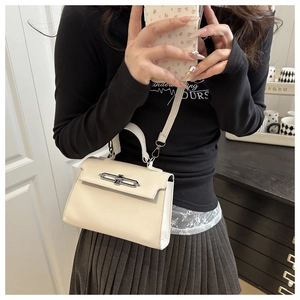 Détail du sac bandoulière blanc crème avec des ferrures argentées et une sangle amovible