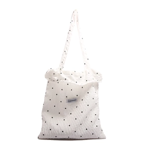 Minimalist cream tote bag with black floral pattern and long shoulder straps