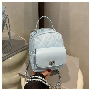Detailed close-up of light blue quilted mini backpack with silver twist-lock and chain strap