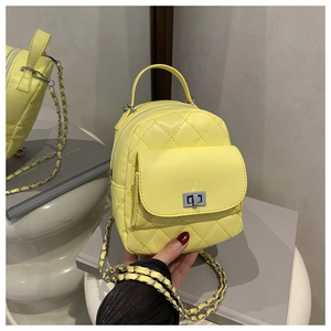 Macro view of lemon yellow quilted mini backpack with silver metal turn-lock and chain