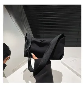 Détail de la bandoulière réglable et de la fermeture éclair d'un sac fourre-tout noir minimaliste