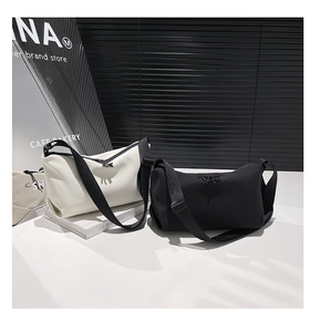 Détail de sacs bandoulière minimalistes noir et blanc avec larges bandoulières
