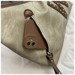 Detail of vintage canvas tote showing side zipper pocket and premium leather trim