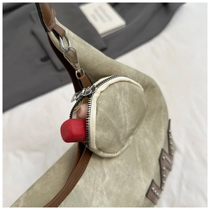 Detail of canvas tote bag with leather trim and mini coin purse holding a lipstick
