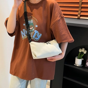 Sac fourre-tout blanc minimaliste avec bandoulière noire réglable porté par un mannequin