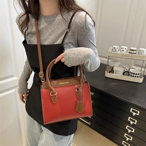 Red and brown patchwork crossbody handbag with gold hardware and adjustable strap