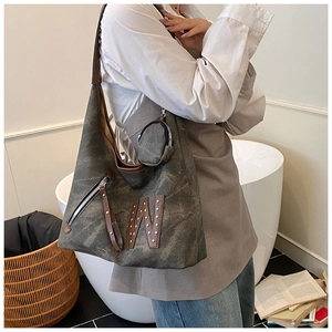 Detail of grey canvas tote with leather W patch and round coin purse attachment