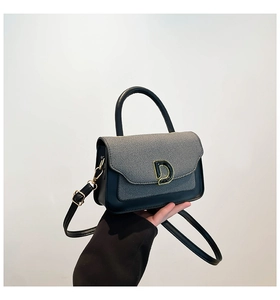 Detail of checkered shoulder bag featuring golden D-buckle and adjustable strap