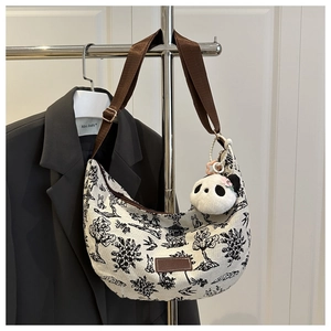 Detail of canvas tote bag with mountain ink painting, panda charm, and adjustable strap