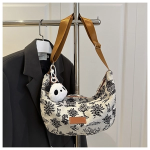 Detail view of canvas hobo bag with panda and landscape print featuring a wide brown strap