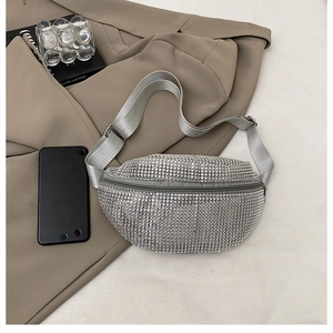 Top view of silver rhinestone waist bag with adjustable wide strap on a blazer