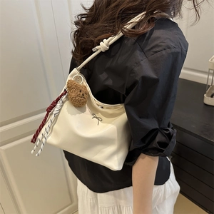Minimalist beige bucket tote bag with cute bear charm and silver bow detail for women