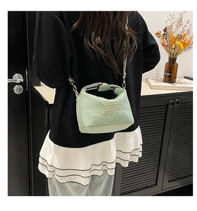 Détail du mini sac vert menthe avec logo SM en rivets dorés et fini brillant