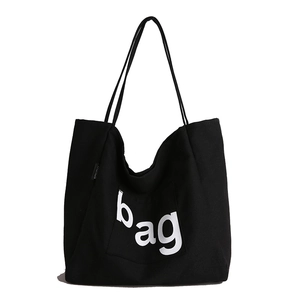 Large black canvas tote bag with white bag lettering and comfortable shoulder straps