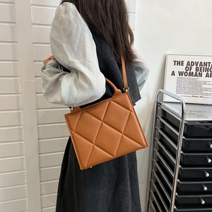 Quilted caramel handbag with diamond stitching shown from a stylish back view