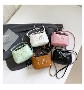 Vue à plat de petits sacs bandoulière en cuir en cinq couleurs avec logo SM perlé