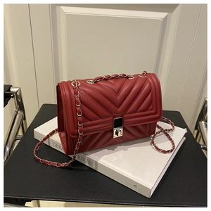 Close-up of red V-quilted leather flap bag with chain strap and square metal lock