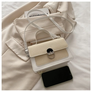 Detail of crossbody bag with beige woven texture, cream leather, and silver metal buckle