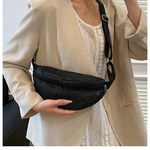 Detail of black crescent crossbody bag with rhinestone finish and nylon shoulder strap
