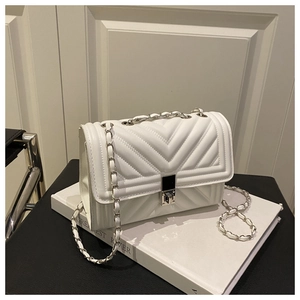 Detail of white chevron quilted leather bag with silver chain strap and square metal lock
